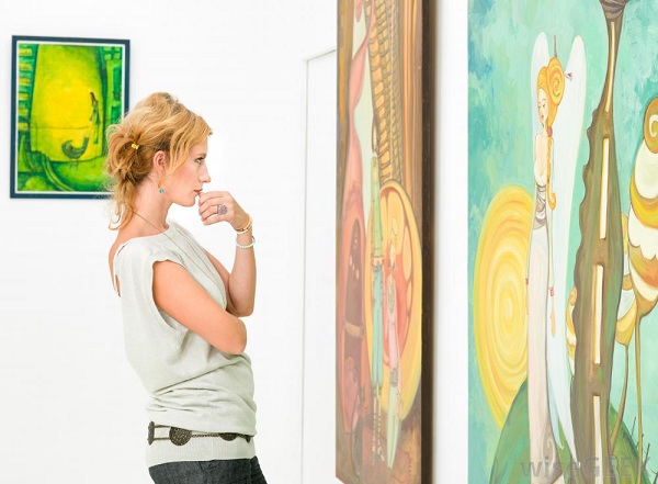 woman-looking-at-paintings-on-wall