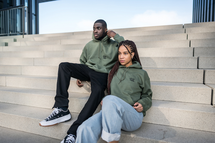boy and girl sitting outside wearing military hoodies