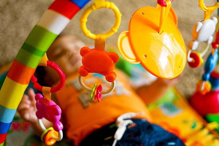picture of a baby playing with toys on playmat 