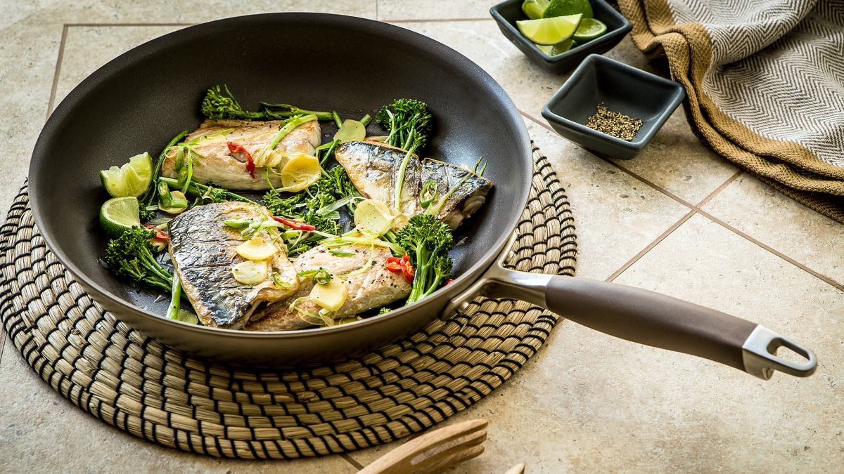 frying pan with cooked fish and vegetables inside
