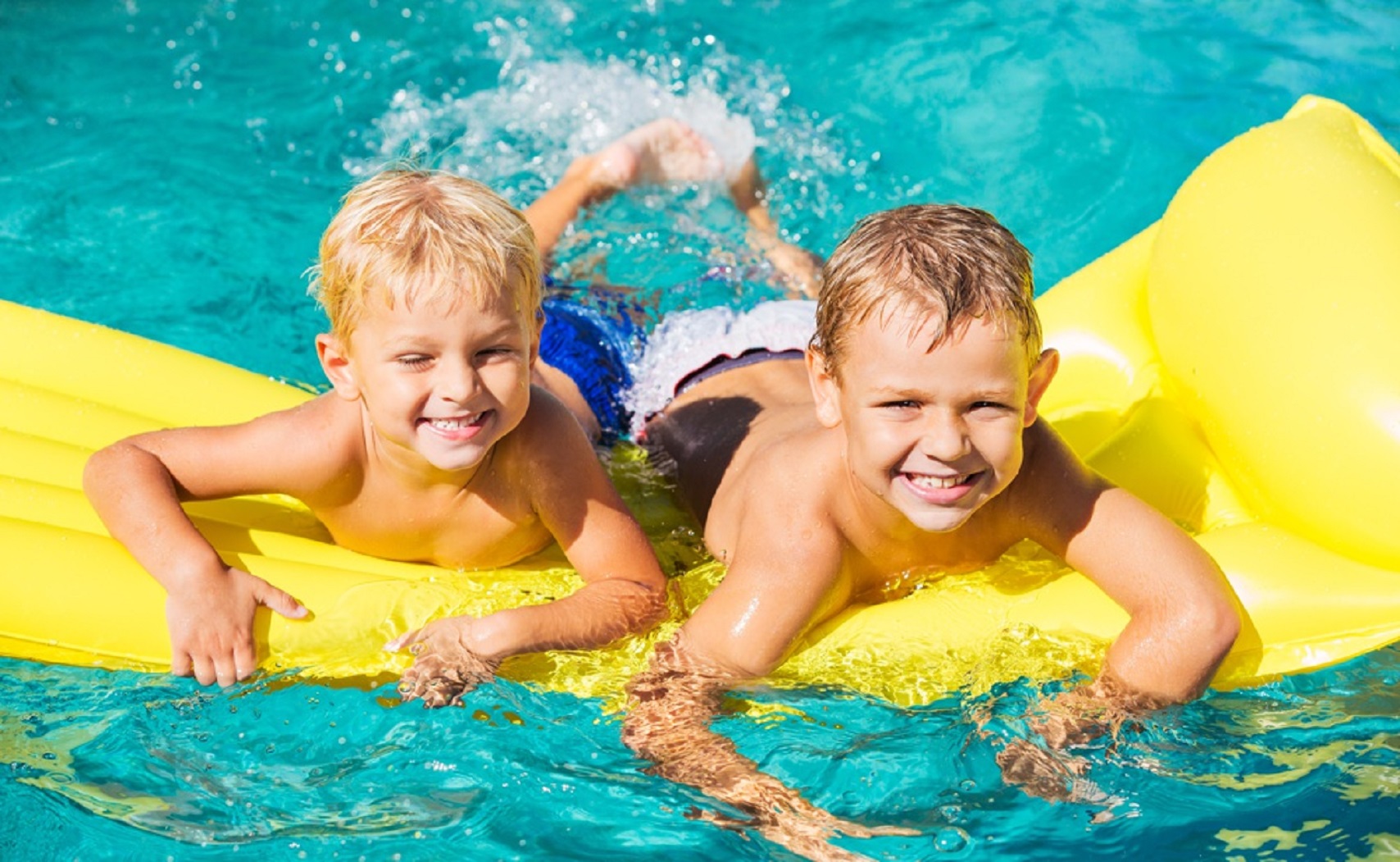 Young Kids Having Fun in Swimming Pool on Yellow Raft