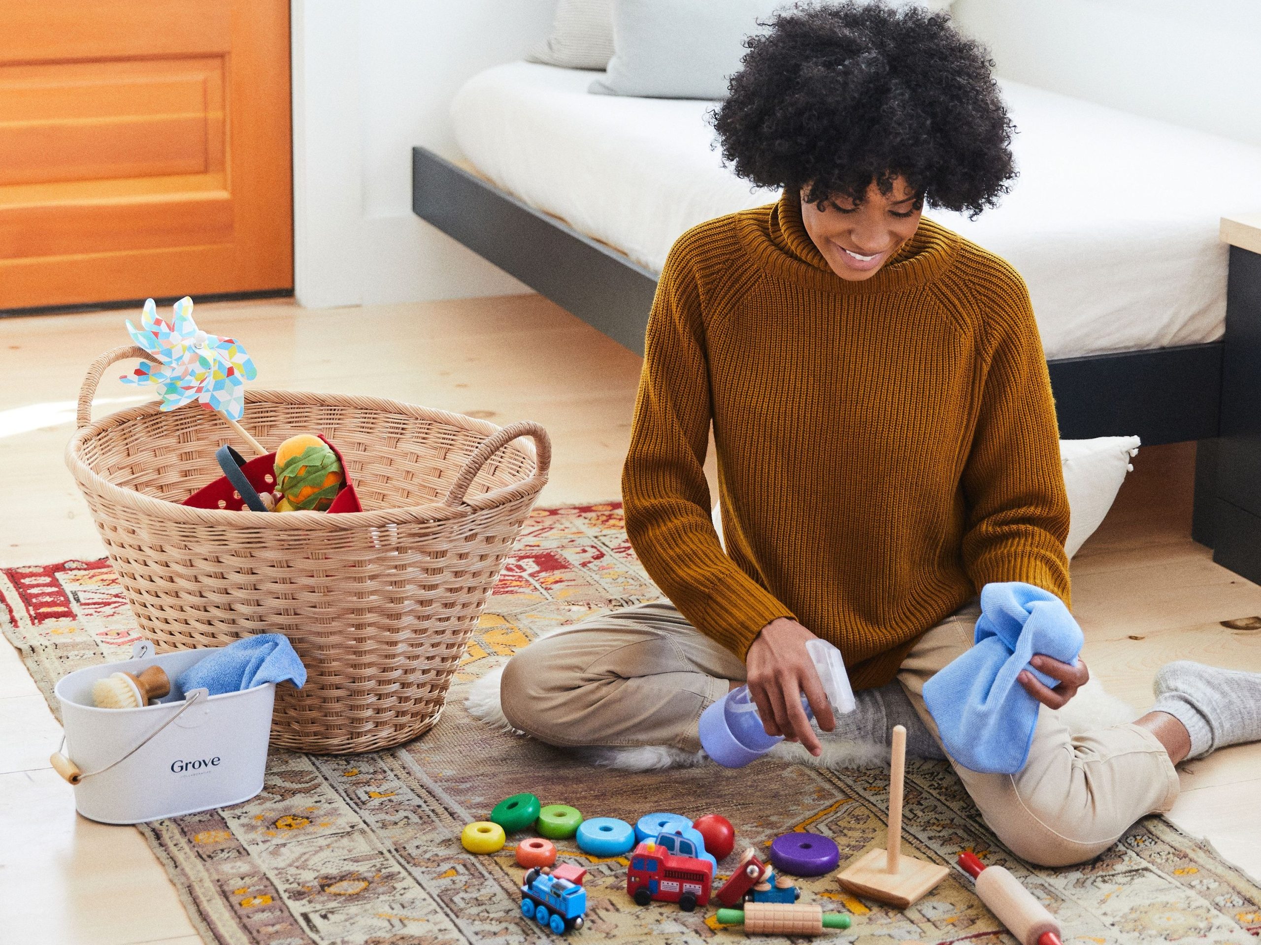 Woman sitting on the carpet and cleaning bunch of wooden toys 