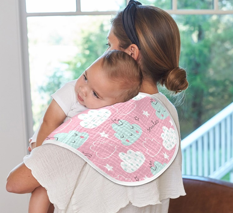 burp cloth over the shoulder of a woman carrying a baby