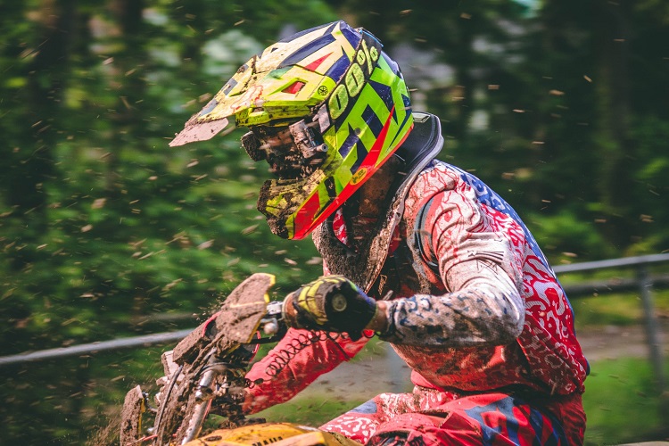 Man riding a motocross with fox jersey and helmet