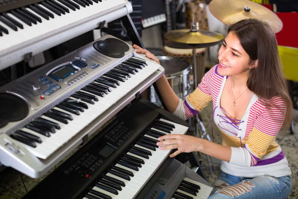 A girl is choosing between two different types of music keyboard